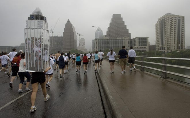 Deanne Breedlove, dressed as the Frost Bank Tower, runs over the Congress Avenue Bridge at the start of the Statesman Capitol 10,000 on Sunday March 30, 2008. [Jay Janner/American-Statesman]