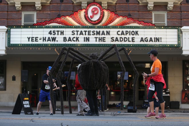 A Cap10k runner competes in a spider costume on Congress Ave. on Sunday April 10, 2022.